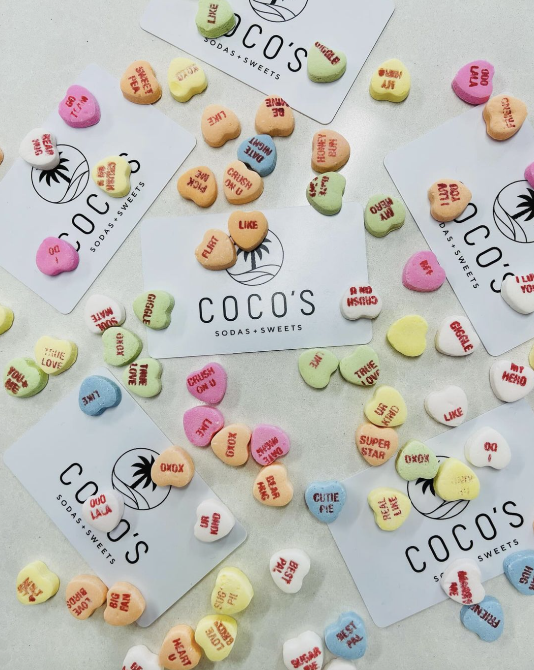 Picture of Coco's gift cards surrounded by candy hearts.